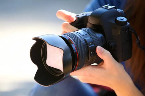 A Young Woman Holding a Full Frame Camera.